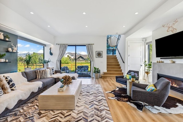 1492 Windrow Dr, Bozeman, MT 59718 - living room with stairway, healthy amount of natural light, a glass covered fireplace, wood finished floors, and recessed lighting