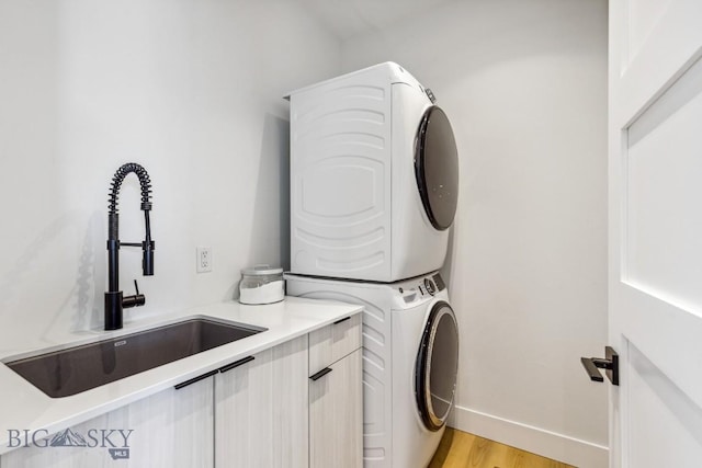 1492 Windrow Dr, Bozeman, MT 59718 - laundry area with stacked washer / dryer, cabinet space, and light wood-type flooring