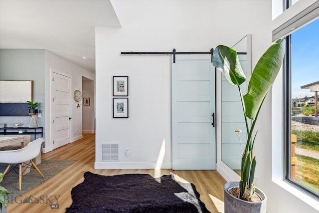 1492 Windrow Dr, Bozeman, MT 59718 - bedroom featuring a barn door, light wood-style floors, and recessed lighting