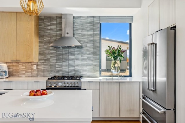 1492 Windrow Dr, Bozeman, MT 59718 - kitchen featuring high quality appliances, wall chimney exhaust hood, modern cabinets, and light countertops