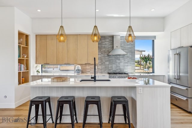1492 Windrow Dr, Bozeman, MT 59718 - kitchen with high end refrigerator, wall chimney range hood, modern cabinets, light brown cabinets, and decorative backsplash
