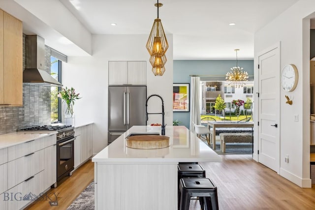 1492 Windrow Dr, Bozeman, MT 59718 - kitchen with wall chimney exhaust hood, high quality appliances, modern cabinets, light countertops, and recessed lighting