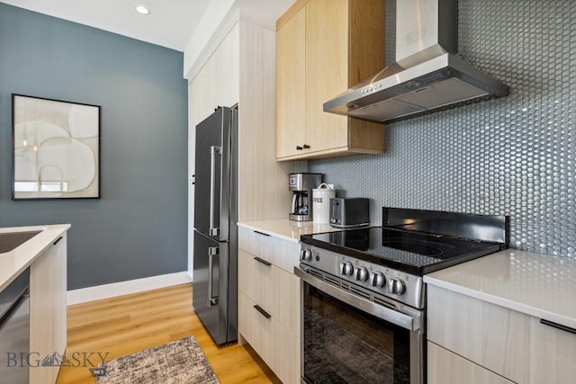 1492 Windrow Dr, Bozeman, MT 59718 - kitchen featuring stainless steel electric stove, wall chimney range hood, high quality fridge, light wood-style floors, and light countertops
