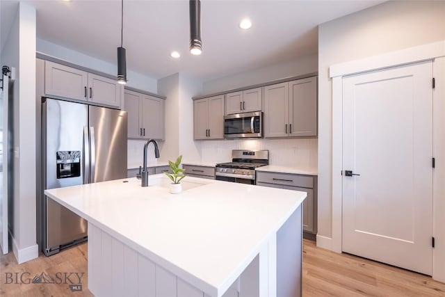 740 Rogers Way Unit A, Bozeman, MT 59718 - kitchen with appliances with stainless steel finishes, gray cabinets, light wood-style floors, a center island with sink, and recessed lighting