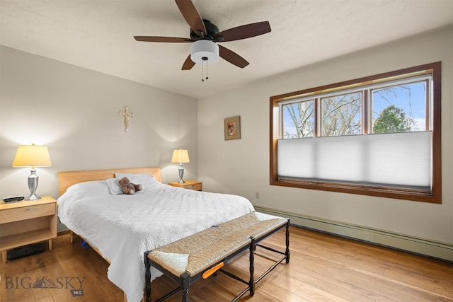 109 Cottonwood St, Manhattan, MT 59741 - bedroom with baseboard heating, wood finished floors, and a ceiling fan