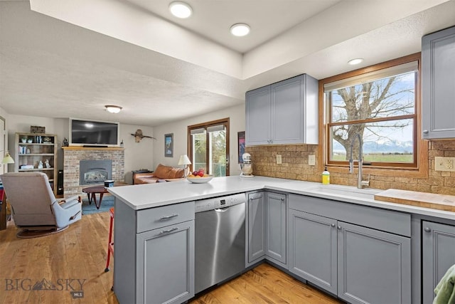 109 Cottonwood St, Manhattan, MT 59741 - kitchen with gray cabinetry, dishwasher, a peninsula, open floor plan, and a fireplace