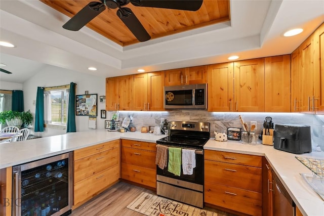 15 Sky Vw, Ennis, MT 59729 - kitchen with appliances with stainless steel finishes, beverage cooler, a ceiling fan, a tray ceiling, and a peninsula