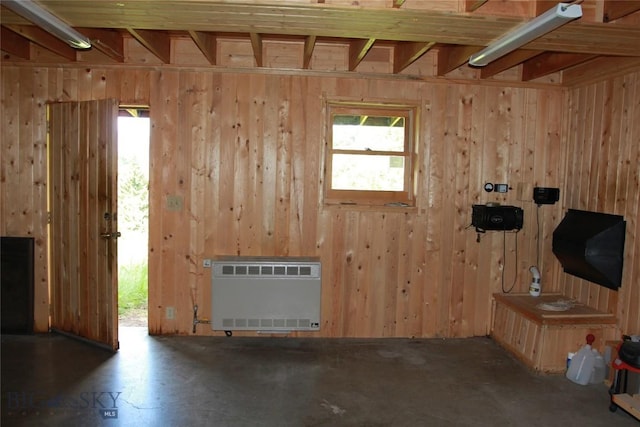 524 Grizzly Meadow Rd, Emigrant, MT 59027 - unfurnished living room featuring heating unit, healthy amount of natural light, and wood walls