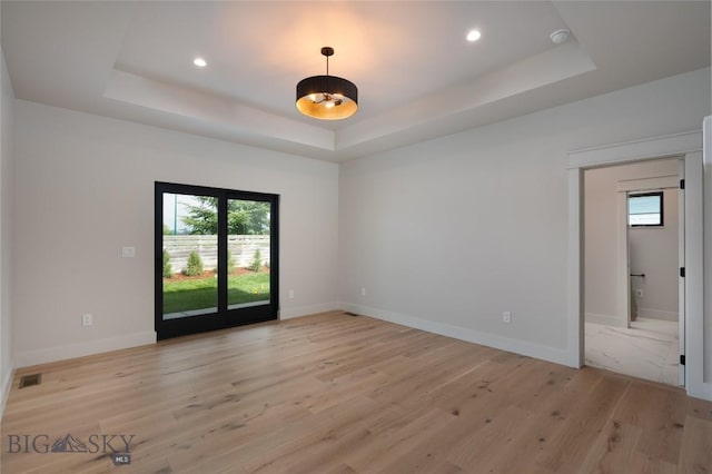 1440 Ryun Sun Way, Bozeman, MT 59718 - unfurnished room featuring a raised ceiling, light wood finished floors, healthy amount of natural light, and recessed lighting