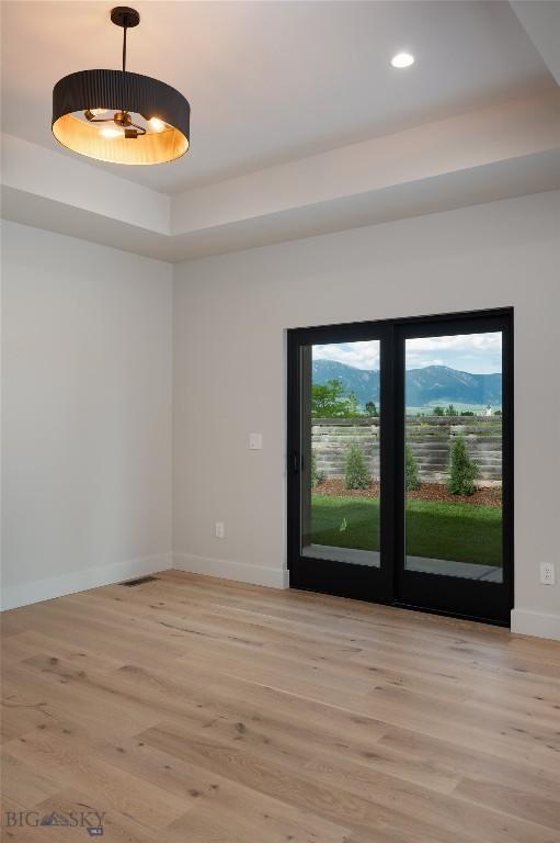 1440 Ryun Sun Way, Bozeman, MT 59718 - empty room with light wood-type flooring, recessed lighting, and a raised ceiling