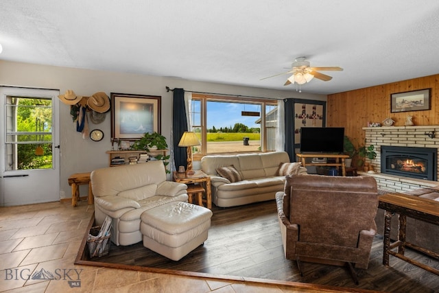 1125 Webster Ln, Dillon, MT 59725 - living area with ceiling fan, wooden walls, and a fireplace