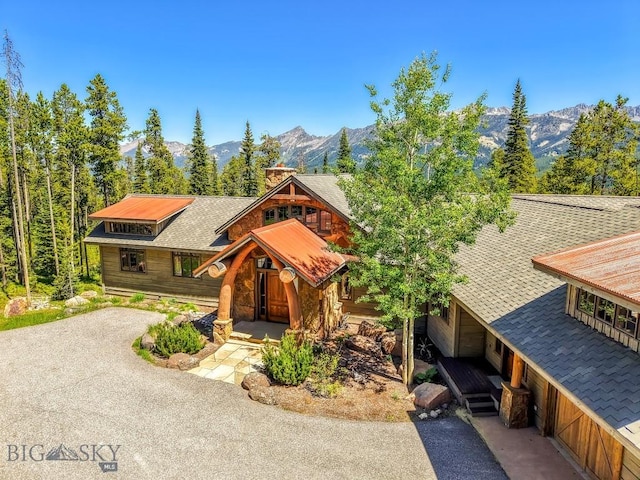 83 Peaks View Dr, Big Sky, MT 59718 - chalet / cabin with a mountain view, a chimney, driveway, and stone siding