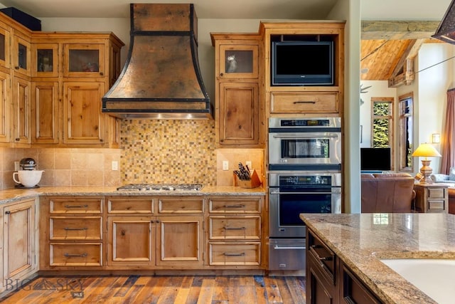 83 Peaks View Dr, Big Sky, MT 59718 - kitchen featuring stainless steel appliances, custom exhaust hood, glass insert cabinets, and backsplash