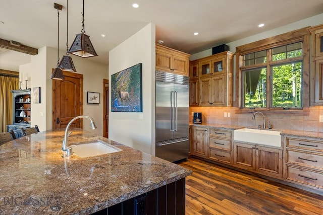 83 Peaks View Dr, Big Sky, MT 59718 - kitchen featuring stainless steel built in fridge, dark wood-style floors, tasteful backsplash, dark stone countertops, and recessed lighting