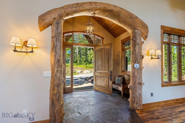 83 Peaks View Dr, Big Sky, MT 59718 - foyer featuring a chandelier, arched walkways, lofted ceiling, and stone finish flooring