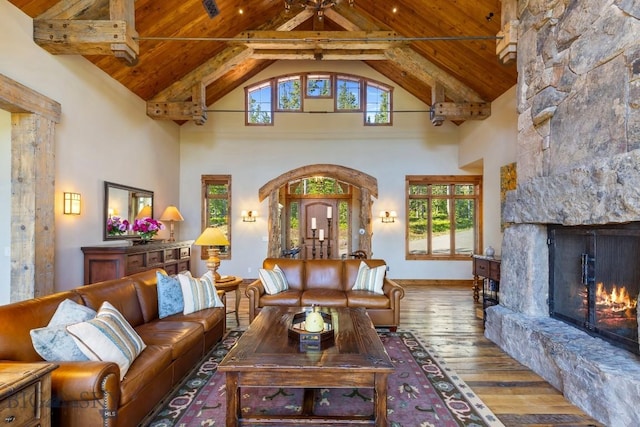 83 Peaks View Dr, Big Sky, MT 59718 - living room featuring a wooden ceiling with exposed beams, high vaulted ceiling, hardwood / wood-style flooring, arched walkways, and a fireplace