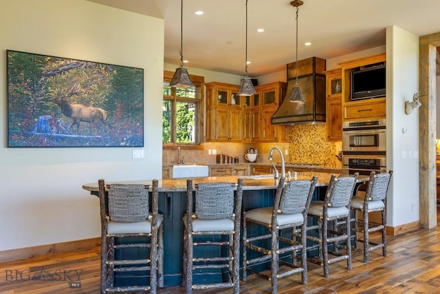 83 Peaks View Dr, Big Sky, MT 59718 - kitchen with dark wood finished floors, brown cabinets, premium range hood, decorative backsplash, and recessed lighting