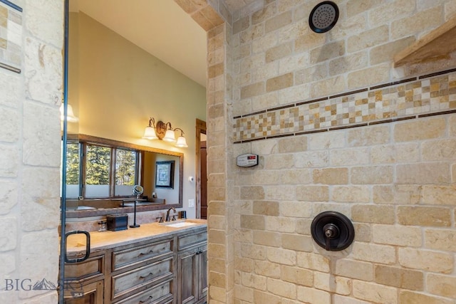 83 Peaks View Dr, Big Sky, MT 59718 - full bathroom with a tile shower, double vanity, and lofted ceiling