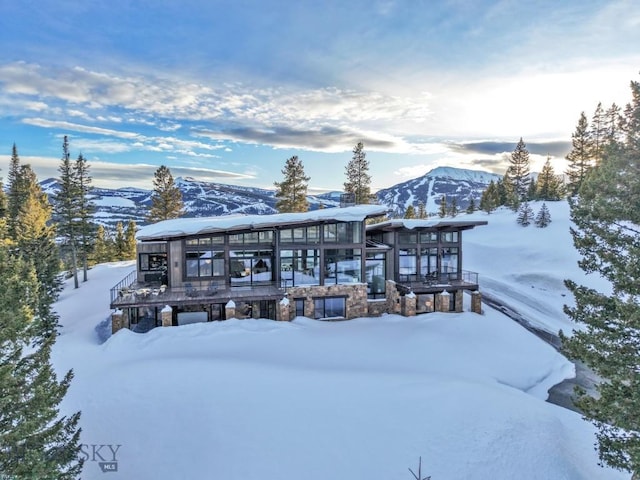 93 Goshawk Trl, Big Sky, MT 59716 - snow covered house with a mountain view and stone siding
