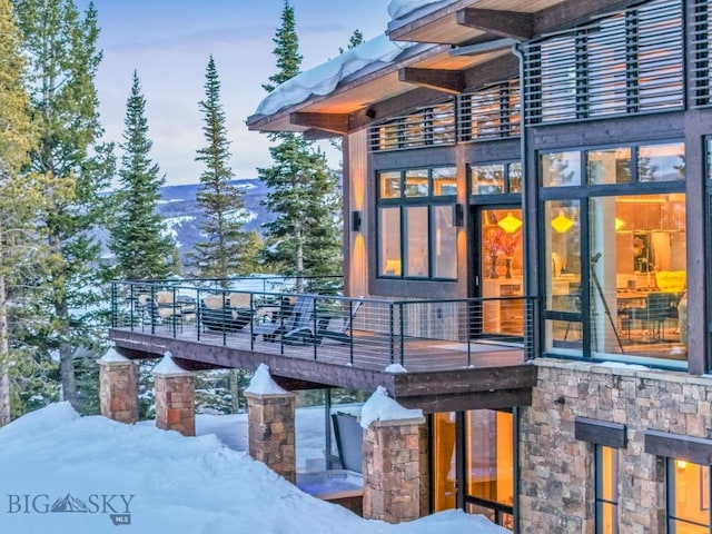 93 Goshawk Trl, Big Sky, MT 59716 - snow covered property with stone siding and a balcony