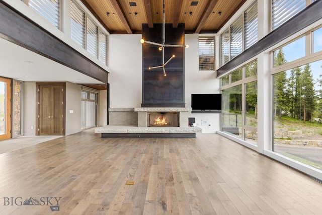 93 Goshawk Trl, Big Sky, MT 59716 - unfurnished living room with a high ceiling, wood ceiling, wood-type flooring, and a fireplace