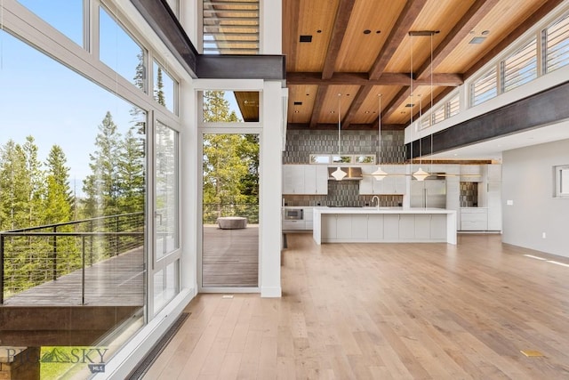 93 Goshawk Trl, Big Sky, MT 59716 - unfurnished living room featuring a high ceiling, light wood finished floors, and a wood ceiling with exposed beams