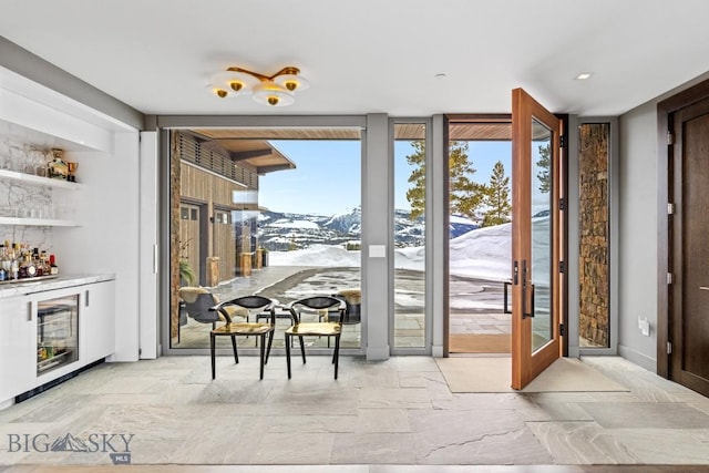 93 Goshawk Trl, Big Sky, MT 59716 - doorway to outside with stone tile floors, a dry bar, expansive windows, and beverage cooler
