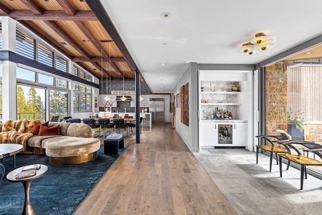 93 Goshawk Trl, Big Sky, MT 59716 - living area featuring wine cooler, hardwood / wood-style floors, a bar, beam ceiling, and built in features