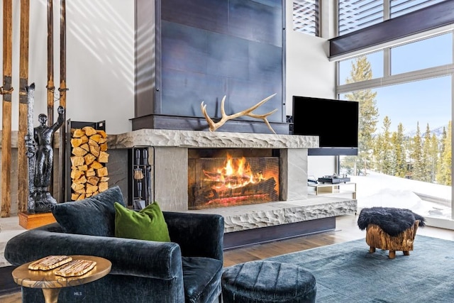 93 Goshawk Trl, Big Sky, MT 59716 - living area with a premium fireplace, healthy amount of natural light, wood finished floors, and a high ceiling