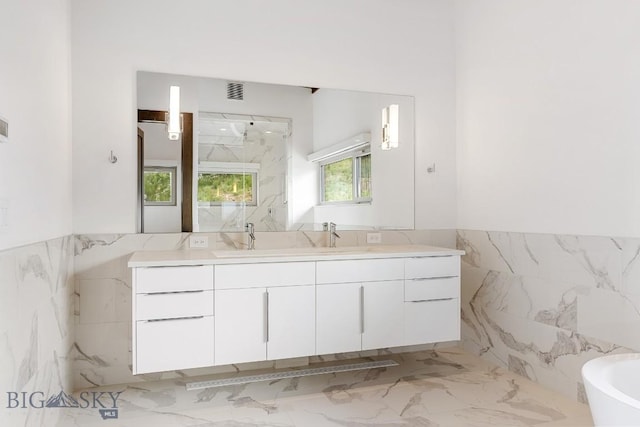 93 Goshawk Trl, Big Sky, MT 59716 - bathroom with tile walls, vanity, a marble finish shower, a soaking tub, and marble tiled floors