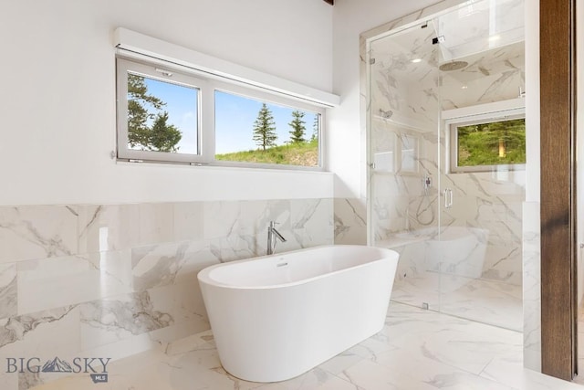 93 Goshawk Trl, Big Sky, MT 59716 - full bath with plenty of natural light, a marble finish shower, tile walls, a freestanding bath, and marble tiled flooring