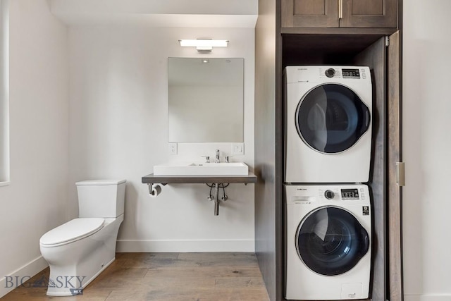 93 Goshawk Trl, Big Sky, MT 59716 - laundry room featuring stacked washer and clothes dryer and wood finished floors