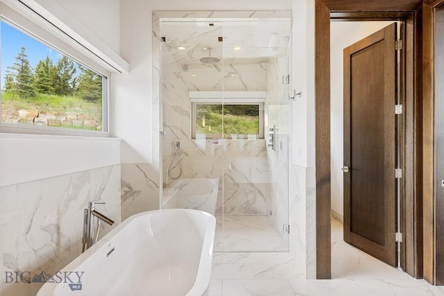 93 Goshawk Trl, Big Sky, MT 59716 - full bath with marble tiled floors, a marble finish shower, a soaking tub, plenty of natural light, and tile walls