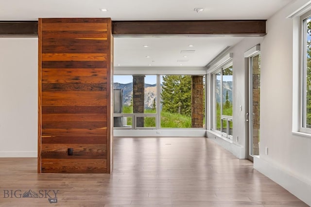 93 Goshawk Trl, Big Sky, MT 59716 - unfurnished living room with wood finished floors and a mountain view