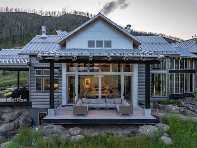 225 Alpen Strasse St, Bozeman, MT 59715 - rear view of property featuring a standing seam roof, a deck, a metal roof, an outdoor living space, and a chimney