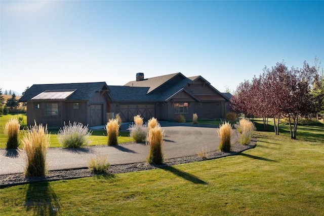 661 Doney Way, Bozeman, MT 59718 - view of front of house featuring a garage, asphalt driveway, a front yard, and a chimney