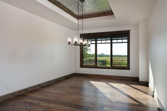 661 Doney Way, Bozeman, MT 59718 - empty room with a raised ceiling, a chandelier, and hardwood / wood-style flooring