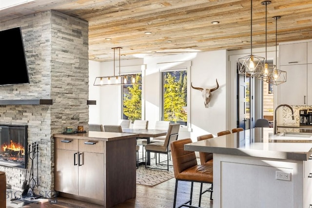 425 Outlook Trl, Big Sky, MT 59716 - kitchen with wooden ceiling, a chandelier, wood finished floors, a breakfast bar, and a fireplace