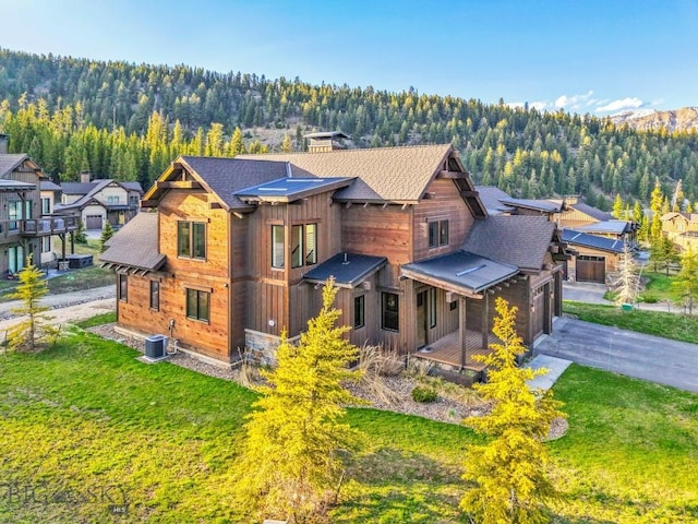 425 Outlook Trl, Big Sky, MT 59716 - back of house with a wooded view, roof with shingles, a lawn, and asphalt driveway