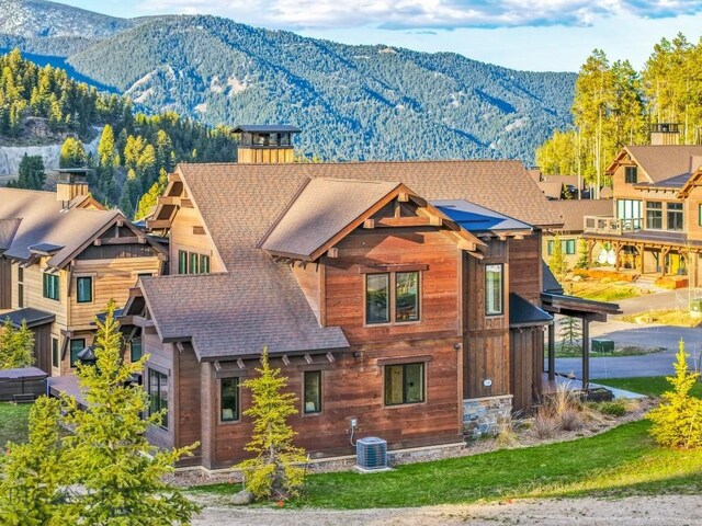 425 Outlook Trl, Big Sky, MT 59716 - view of front of home featuring a mountain view, a shingled roof, and a chimney
