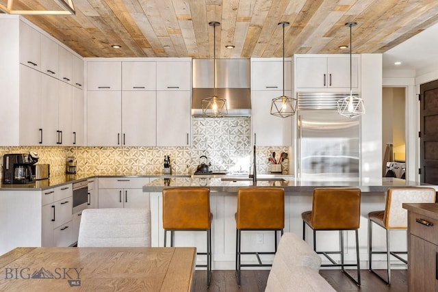 425 Outlook Trl, Big Sky, MT 59716 - kitchen with built in fridge, separate washer and dryer, wall chimney exhaust hood, wooden ceiling, and dark wood-style flooring