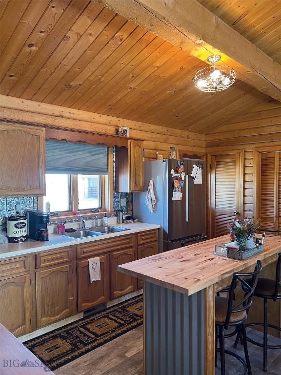 143 Aurora Ln, Dillon, MT 59725 - kitchen with butcher block countertops, freestanding refrigerator, wood ceiling, dark wood-style floors, and a kitchen breakfast bar