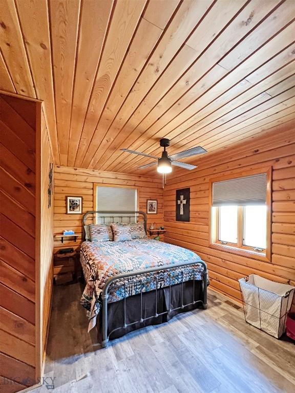 143 Aurora Ln, Dillon, MT 59725 - bedroom featuring wood ceiling, wood-type flooring, and wooden walls