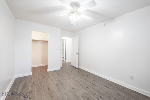 1010 Cruiser Ln Unit M, Belgrade, MT 59714 - unfurnished bedroom with wood finished floors, a closet, and a ceiling fan