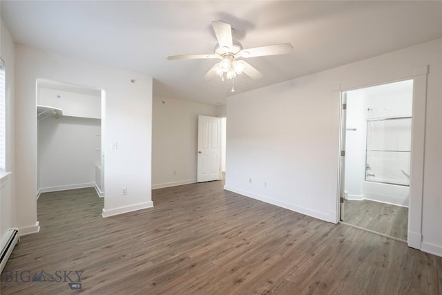1010 Cruiser Ln Unit M, Belgrade, MT 59714 - unfurnished bedroom featuring wood finished floors, a spacious closet, baseboard heating, a closet, and ensuite bathroom