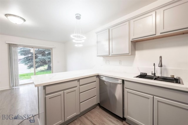 1010 Cruiser Ln Unit M, Belgrade, MT 59714 - kitchen featuring stainless steel dishwasher, a peninsula, gray cabinets, light wood finished floors, and hanging light fixtures