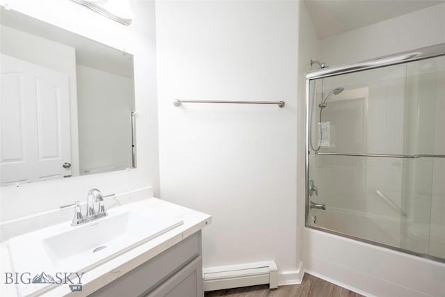 1010 Cruiser Ln Unit M, Belgrade, MT 59714 - bathroom with a baseboard heating unit, vanity, combined bath / shower with glass door, and wood finished floors