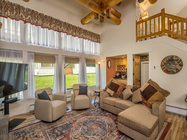 80 Crail Creek Ct Unit 616, Big Sky, MT 59716 - living area featuring baseboard heating, a high ceiling, wood finished floors, and a baseboard heating unit