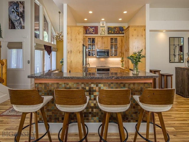 80 Crail Creek Ct Unit 616, Big Sky, MT 59716 - bar area featuring appliances with stainless steel finishes, light wood-type flooring, recessed lighting, and tasteful backsplash