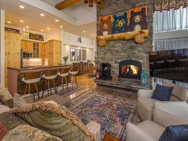 80 Crail Creek Ct Unit 616, Big Sky, MT 59716 - living room with wood finished floors, beam ceiling, a towering ceiling, recessed lighting, and a stone fireplace
